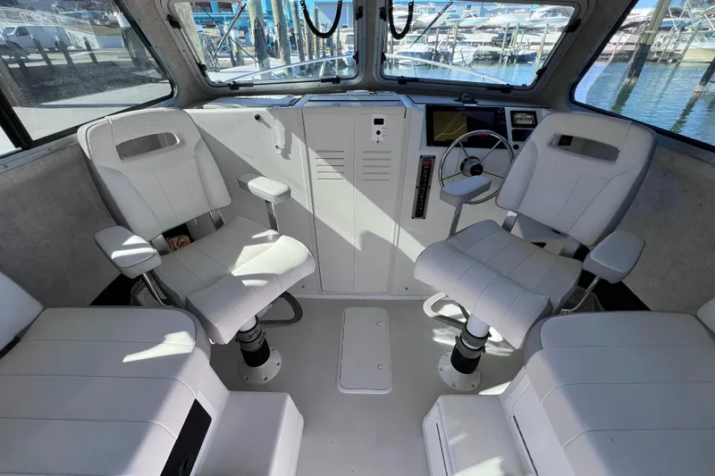 Slide: The Image of Interior of 2023 Parker 2820 XLD Sport Cabin with white seating and navigation controls. - 63