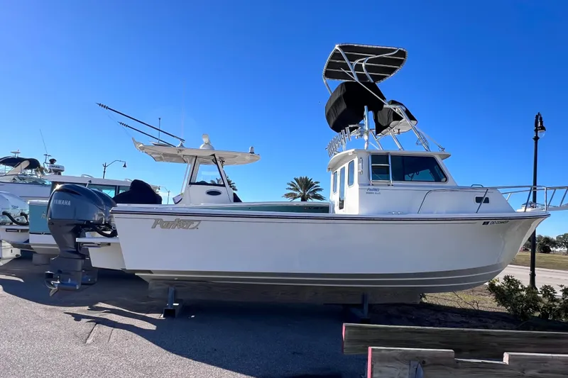 Slide: The Image of 2023 Parker 2820 XLD Sport Cabin boat with Yamaha engine, docked under clear blue sky. - 9