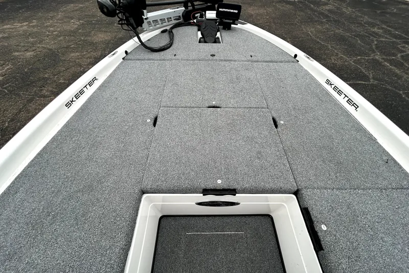 Slide: The Image of 2010 Skeeter 20i boat deck with gray carpet and storage compartments. - 15