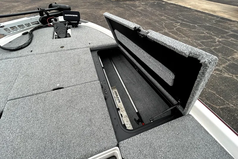 Slide: The Image of 2010 Skeeter 20i boat deck with open storage compartment and fishing equipment. - 18