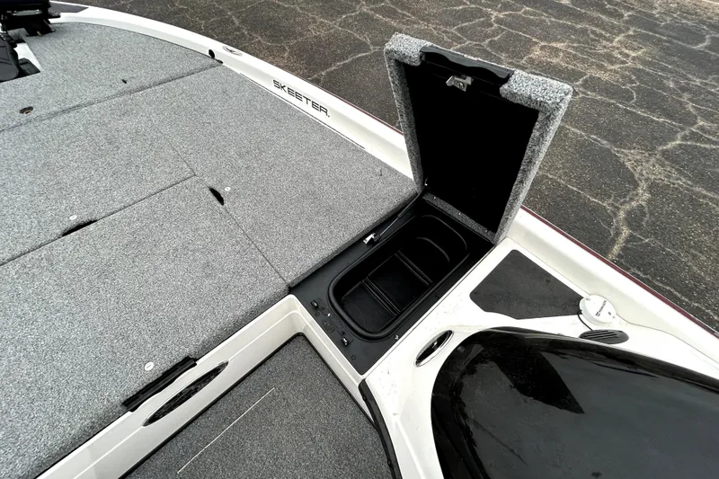 Slide: The Image of 2010 Skeeter 20i boat with open storage compartment on carpeted deck. - 20