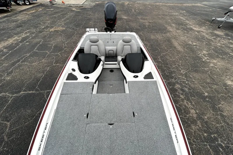 Slide: The Image of 2010 Skeeter 20i boat with dual seats and spacious deck on asphalt surface. - 23