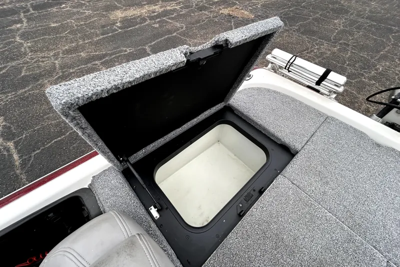 Slide: The Image of Open storage compartment on 2010 Skeeter 20i boat with gray carpeted deck. - 29