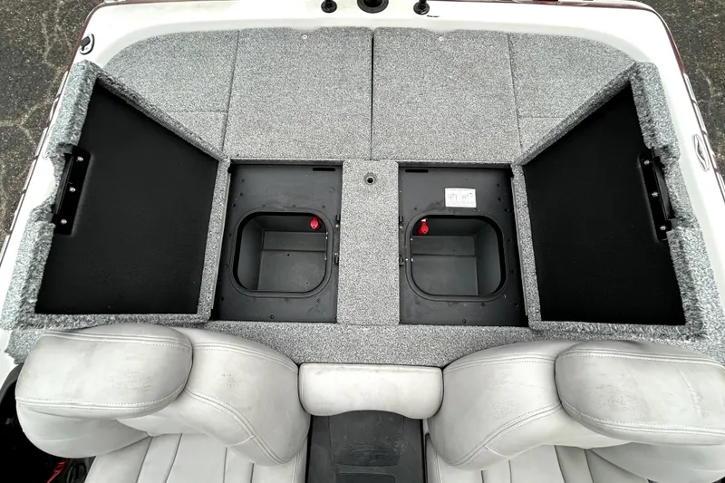 Slide: The Image of 2010 Skeeter 20i boat interior with open storage compartments and gray seating. - 31