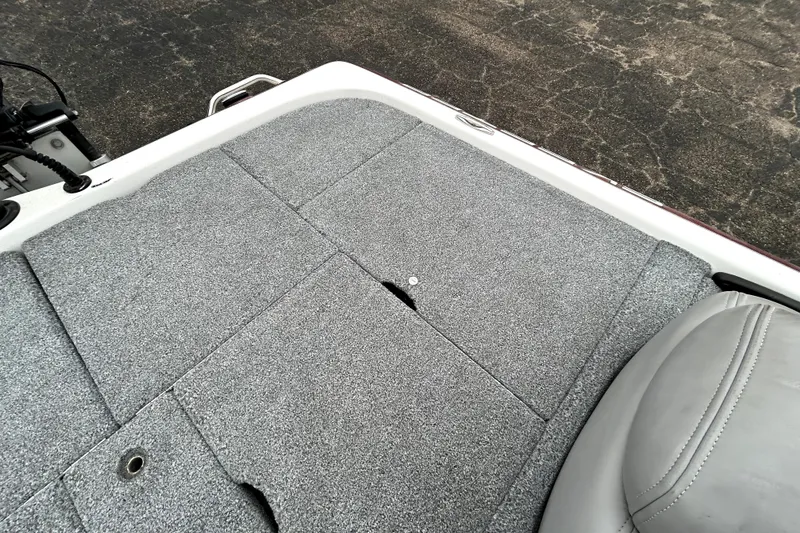 Slide: The Image of 2010 Skeeter 20i boat deck with gray carpet and seating. - 32