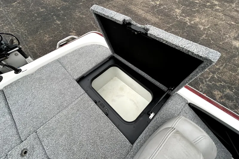 Slide: The Image of Open storage compartment on 2010 Skeeter 20i boat with gray carpeted deck. - 33