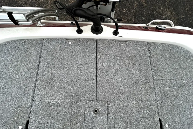 Slide: The Image of 2010 Skeeter 20i boat deck with gray carpet and fishing rod holders. - 34