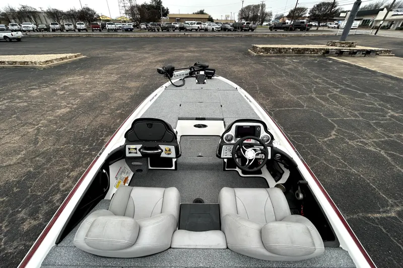 Slide: The Image of 2010 Skeeter 20i boat interior with steering wheel and seating, parked on asphalt. - 36