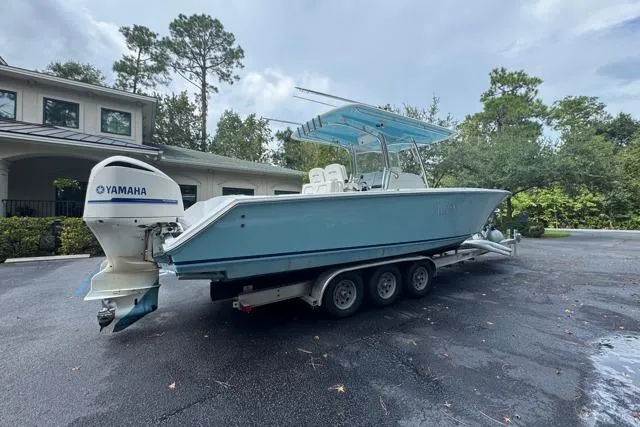 Slide: The Image of 2014 Jupiter 34 boat with Yamaha engine on a trailer, parked outdoors. - 22