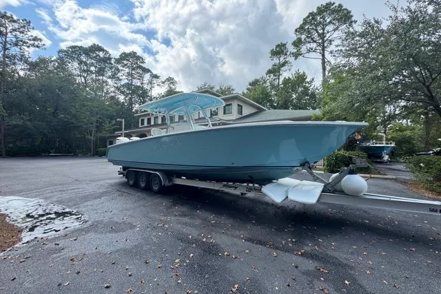 Slide: The Image of 2014 Jupiter 34 boat on trailer in a wooded residential area. - 23