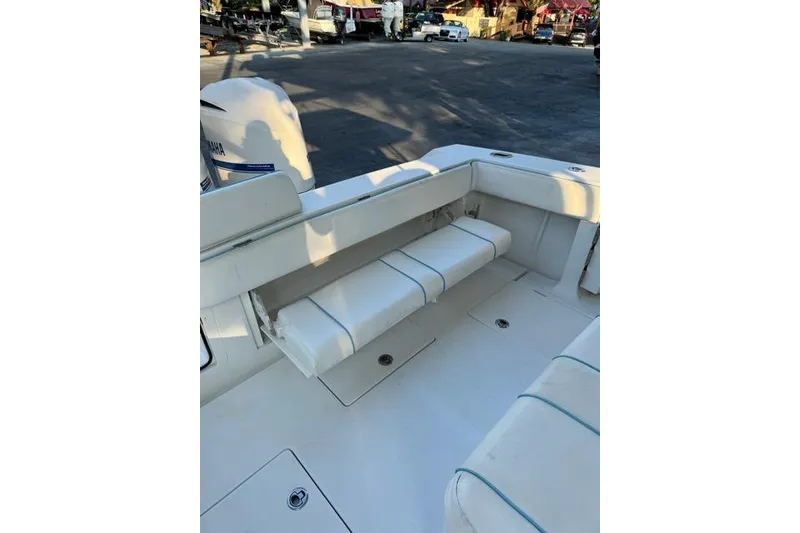 Slide: The Image of 2014 Jupiter 34 boat interior with white cushioned seating and Yamaha engine. - 5