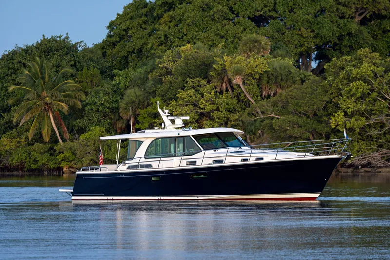 The Image of 2027 Sabre 51 Salon Express yacht cruising near lush tropical shoreline. - 0
