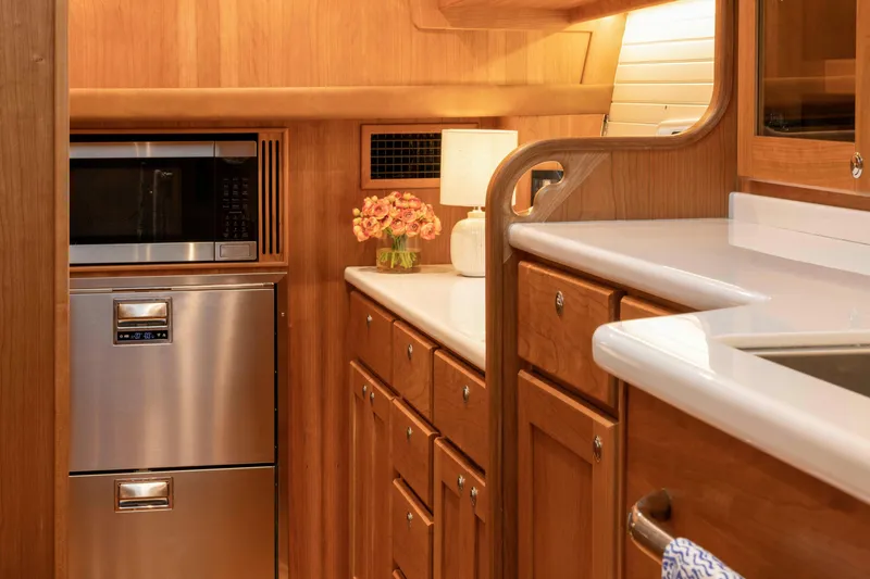 Slide: The Image of Luxurious 2027 Sabre 51 Salon Express yacht kitchen with wood cabinetry and modern appliances. - 17