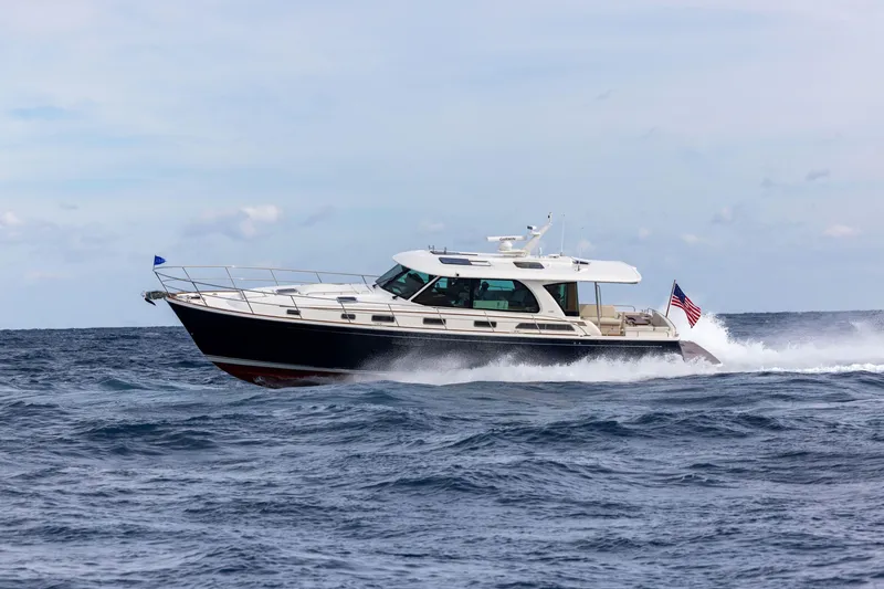Slide: The Image of 2027 Sabre 51 Salon Express yacht cruising on open sea with American flag. - 6