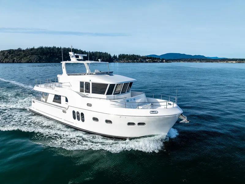 Slide: The Image of 2024 Northwest 55 yacht cruising on open water, with scenic island backdrop. - 2