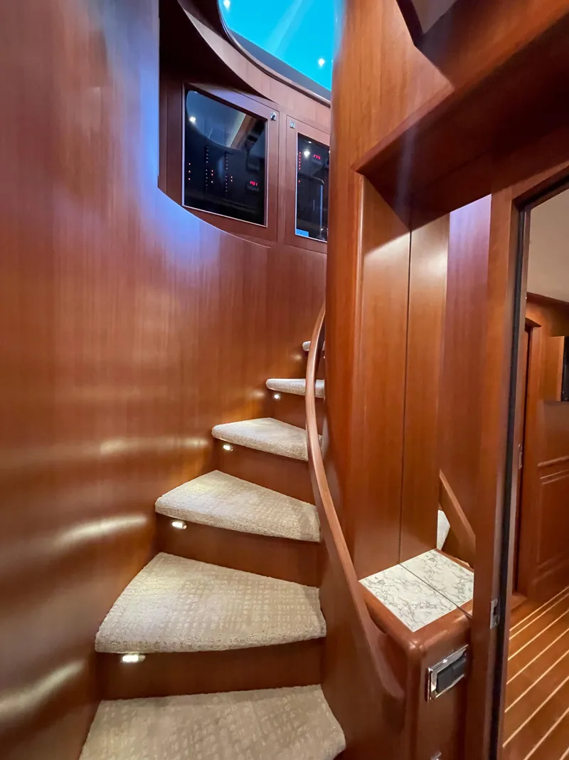 Slide: The Image of Curved wooden staircase inside 2024 Northwest 55 yacht, featuring carpeted steps and modern design. - 30