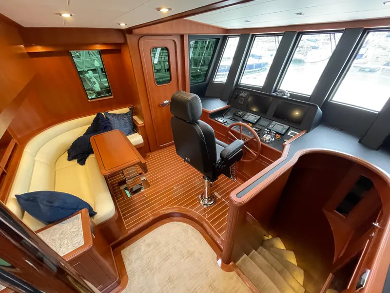 Slide: The Image of Luxurious 2024 Northwest 55 yacht interior with helm, seating area, and wood finishes. - 38
