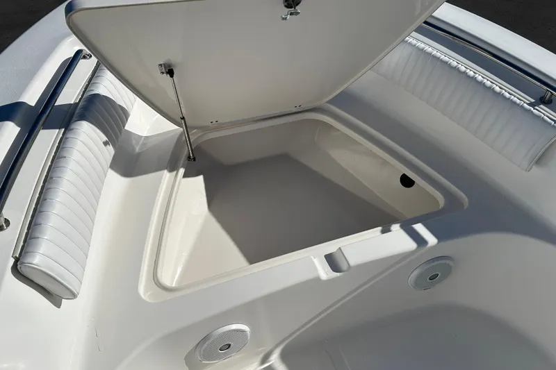 Slide: The Image of 2011 Tidewater 216 CC Adventure boat storage compartment with open lid and cushioned seating. - 14