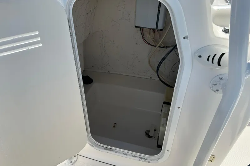 Slide: The Image of Open storage compartment on 2011 Tidewater 216 CC Adventure boat, showing interior wiring. - 16