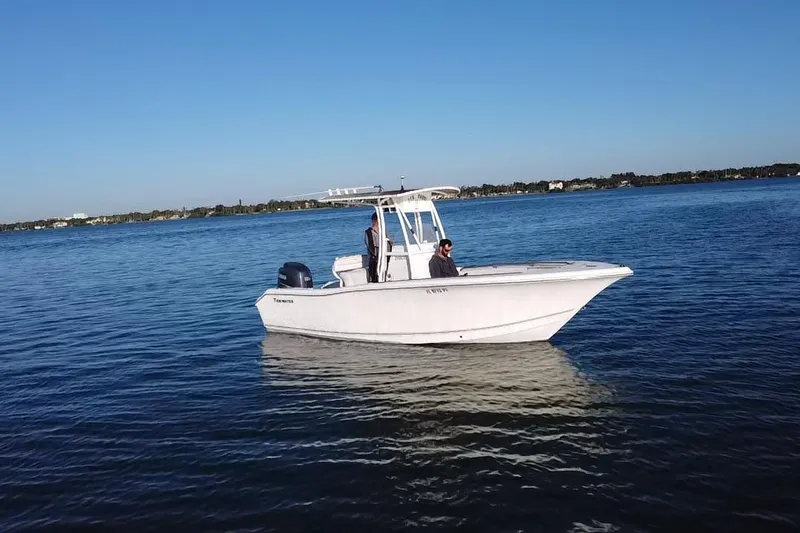 Slide: The Image of 2011 Tidewater 216 CC Adventure boat on calm water under clear blue sky. - 19