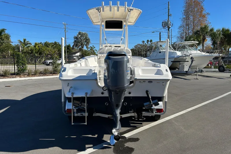 Slide: The Image of 2011 Tidewater 216 CC Adventure boat with Yamaha outboard motor, parked outdoors. - 3