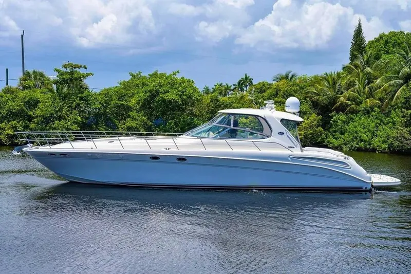 Slide: The Image of 2004 Sea Ray 550 Sundancer yacht cruising on a serene waterway with lush greenery. - 26