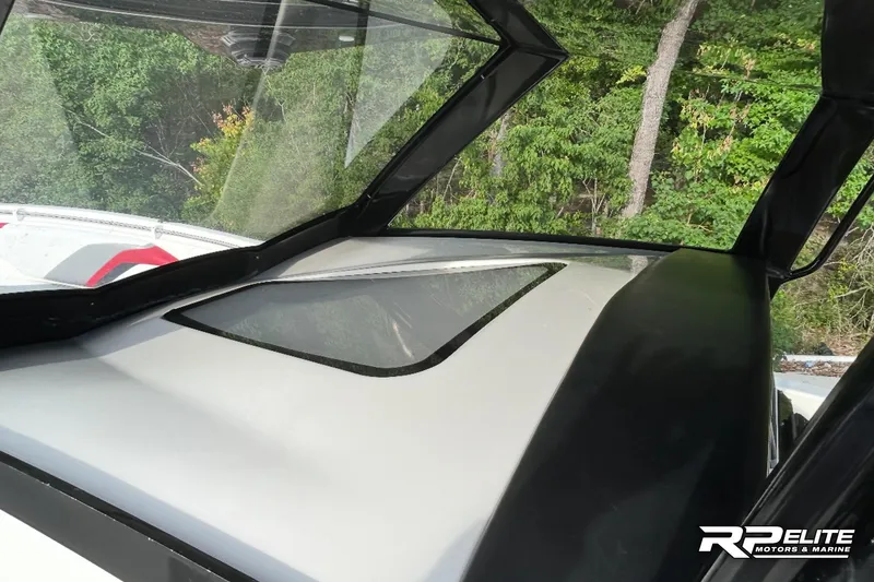 Slide: The Image of 2013 Sunsation 34 CCX boat windshield and dashboard, surrounded by lush greenery. - 14