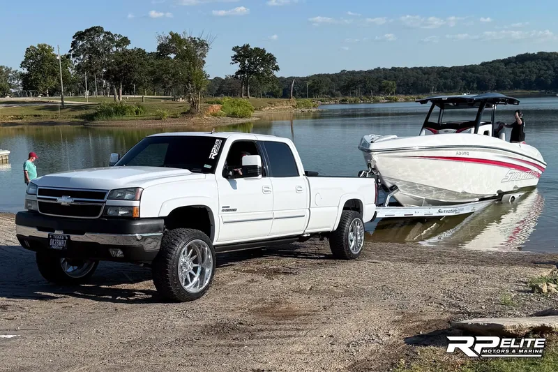 Slide: The Image of White Chevrolet truck towing 2013 Sunsation 34 CCX boat at a lakeside ramp. - 32