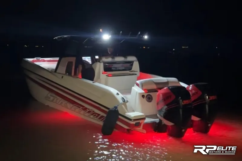 Slide: The Image of 2013 Sunsation 34 CCX boat illuminated at night with red underwater lights. - 35
