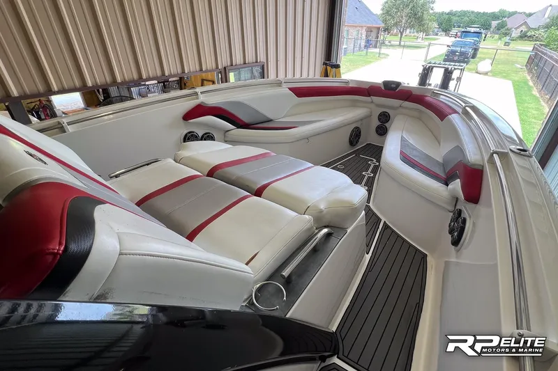 Slide: The Image of 2013 Sunsation 34 CCX boat interior with red and white seating, docked in a garage. - 9