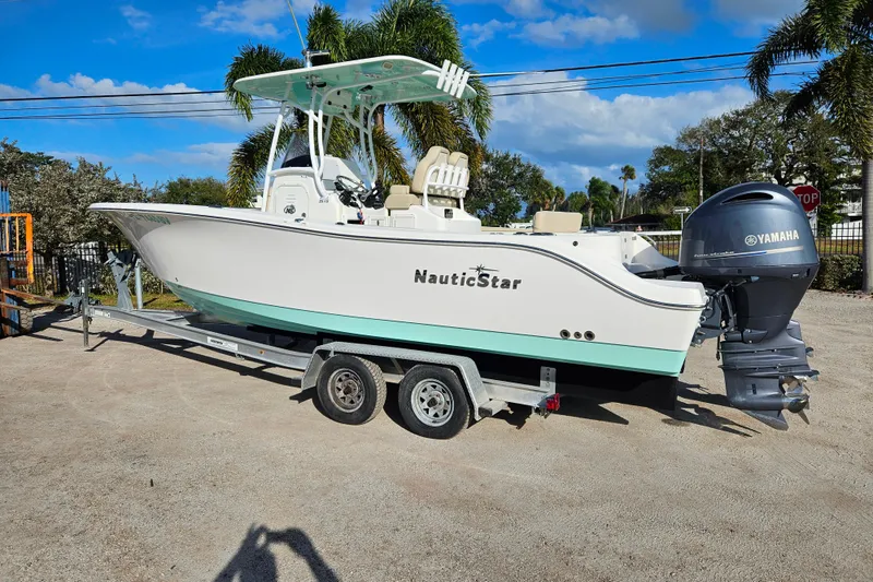 The Image of 2018 NauticStar 25 XS boat on trailer with Yamaha outboard motor, parked outdoors. - 1