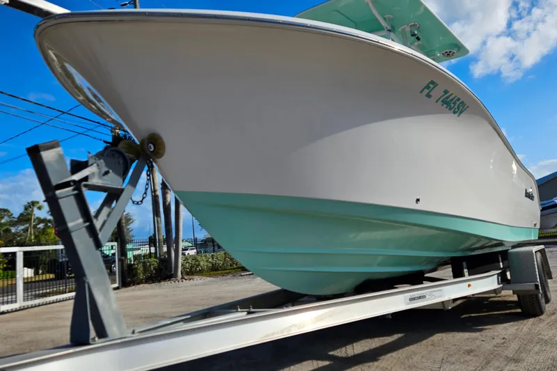 Slide: The Image of 2018 NauticStar 25 XS boat on trailer, clear sky background. - 21
