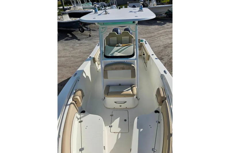 Slide: The Image of 2018 NauticStar 25 XS boat interior with seating and console, docked outdoors. - 6
