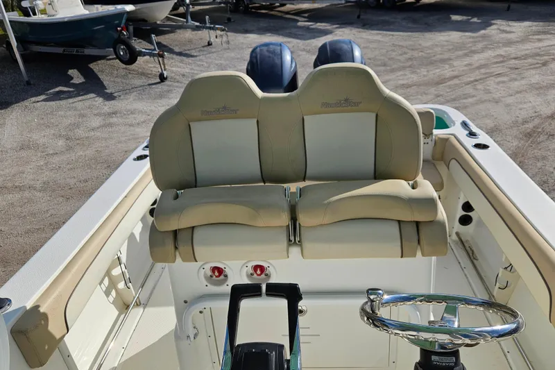 Slide: The Image of 2018 NauticStar 25 XS boat interior with dual seats and steering wheel. - 7