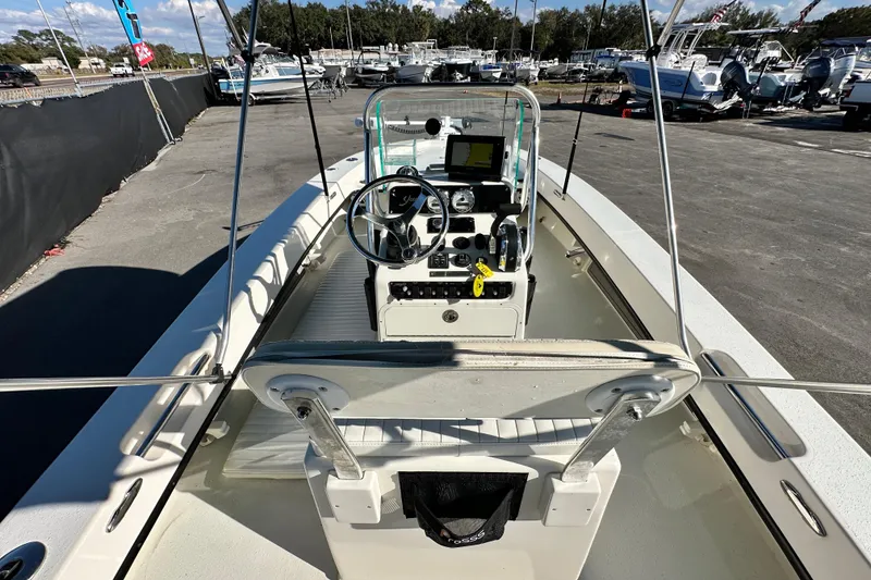 Slide: The Image of 2014 Young Boats 20 Bay Boat interior with steering console and seating, docked outdoors. - 14