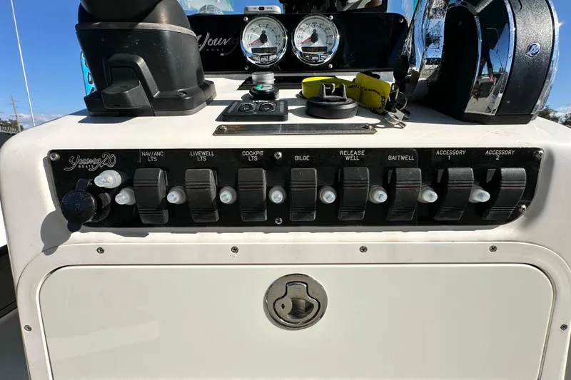 Slide: The Image of Control panel of a 2014 Young Boats 20 bay boat with various switches and gauges. - 17