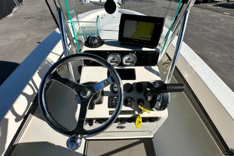 Slide: The Image of 2014 Young Boats 20 Bay Boat dashboard with steering wheel and navigation system. - 20