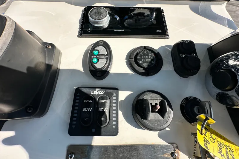 Slide: The Image of Control panel of a 2014 Young Boats 20 bay boat with various switches and dials. - 23
