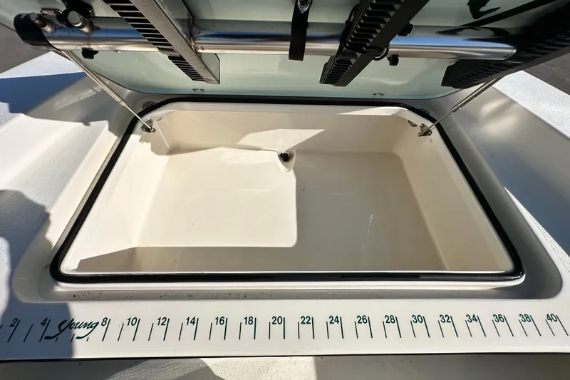 Slide: The Image of Open storage compartment on a 2014 Young Boats 20 bay boat with measuring scale. - 31