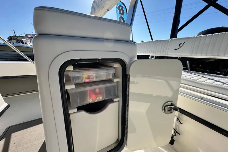 Slide: The Image of 2014 Young Boats 20 Bay Boat storage compartment with tackle boxes. - 46