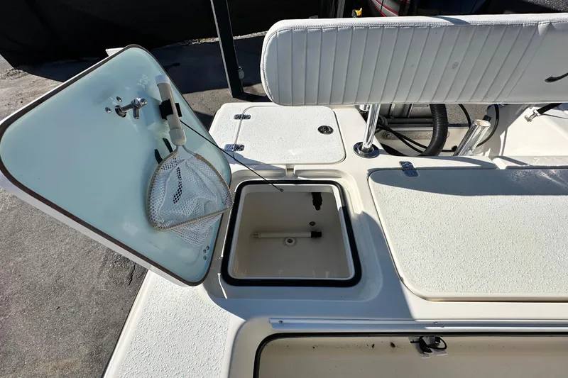 Slide: The Image of 2014 Young Boats 20 Bay Boat interior with storage compartments and fishing net. - 49