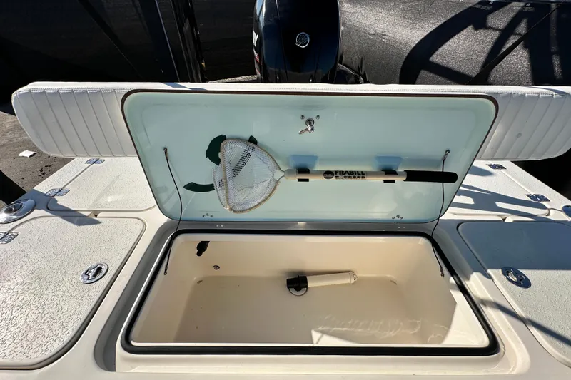 Slide: The Image of 2014 Young Boats 20 Bay Boat storage compartment with fishing net and accessories. - 51