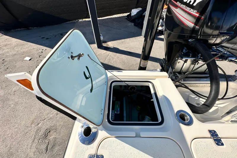Slide: The Image of Open hatch on a 2014 Young Boats 20 bay boat, revealing storage compartment. - 55