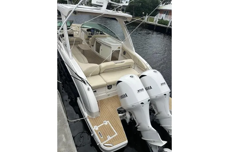 The Image of 2019 Regal 33 OBX boat with twin Yamaha 350 engines docked by the water. - 0