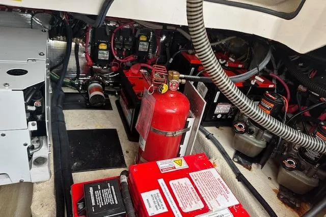 Slide: The Image of Engine compartment of a 2019 Regal 33 OBX boat, featuring batteries and fire extinguisher. - 27