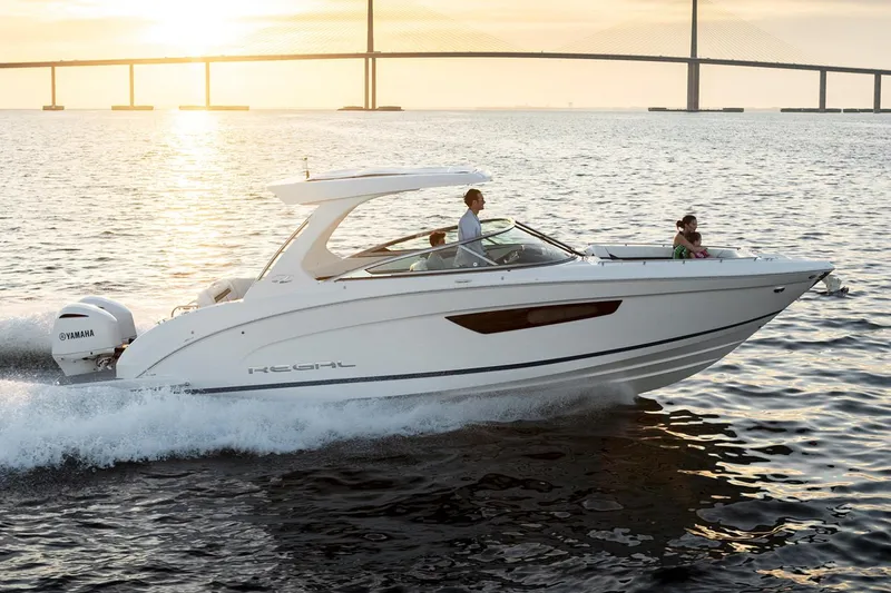 Slide: The Image of Manufacturer Provided Image: 2019 Regal 33 OBX boat cruising on water at sunset. - 4