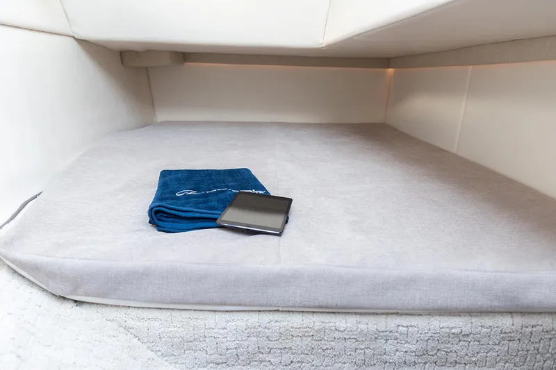 Slide: The Image of Manufacturer Provided Image: 2019 Regal 33 OBX cabin bed with blue towel and tablet. - 8