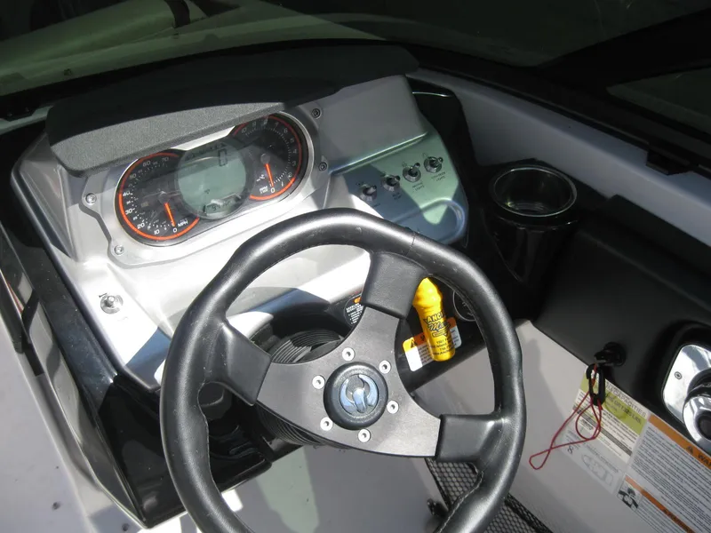 Slide: The Image of 2016 Scarab 195 HO Impulse boat dashboard with steering wheel and gauges. - 2