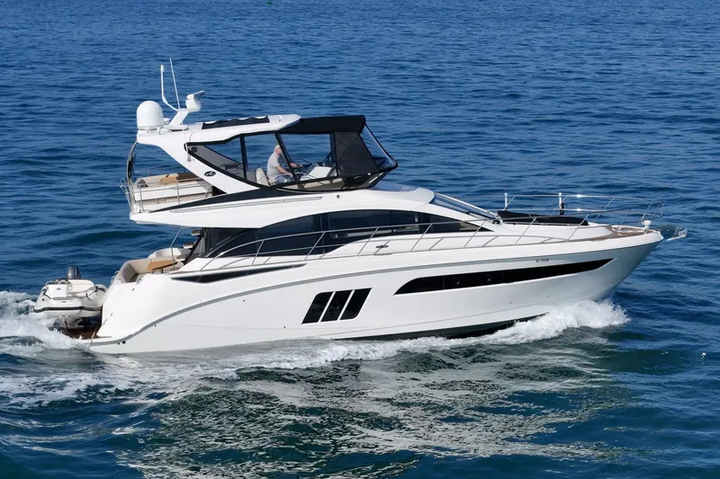 Slide: The Image of 2018 Sea Ray Fly 510 yacht cruising on open blue water. - 12