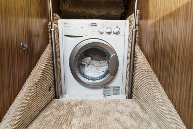 Slide: The Image of Washing machine in 2018 Sea Ray Fly 510 yacht interior, surrounded by wood paneling. - 46